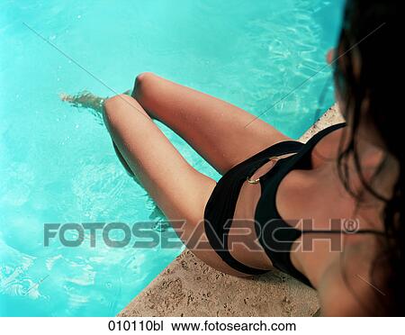 young woman in bikini sitting at poolside View Large Photo Image Stock Image - young woman in bikini sitting at poolside. Fotosearch