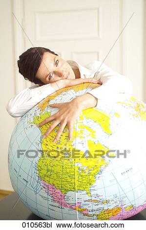 young woman leaning over an inflatable globe View Large Photo Image Stock Image - young woman leaning over an inflatable globe. Fotosearch
