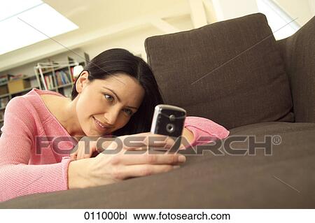 Young woman looking at display of mobile View Large Photo Image Stock Image - Young woman looking at display of mobile. Fotosearch