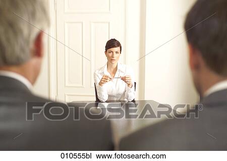 young woman sitting at a conference table with two businessmen in the foreground View Large Photo Image Stock Image - young woman sitting at a conference table with two businessmen in the foreground. Fotosearch