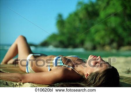 young woman taking a sunbath on a tropical beach View Large Photo Image Stock Image - young woman taking a sunbath on a tropical beach. Fotosearch