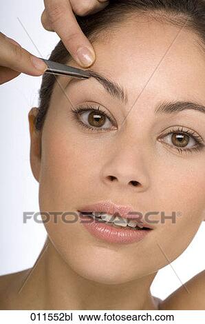 a young woman plucking her eyebrows View Large Photo Image Stock Image - a young woman plucking her eyebrows. Fotosearch