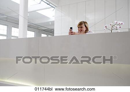 blonde woman having fun with her mobile View Large Photo Image Stock Image - blonde woman having fun with her mobile. Fotosearch