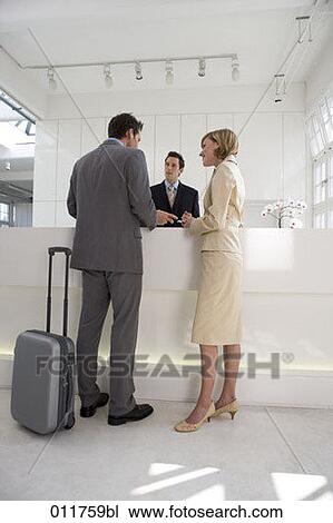Stock Image - business couple talking at reception in office building. Fotosearch
