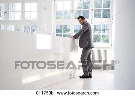 Stock Image - businessman standing at reception desk. Fotosearch