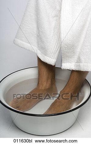 Stock Image - close-up of feet taking a footbath. Fotosearch