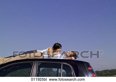 couple relaxing on car top View Large Photo Image Stock Image - couple relaxing on car top. Fotosearch