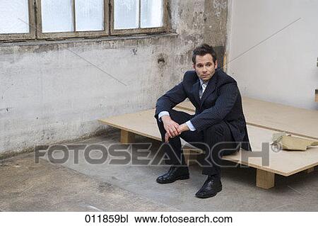 disappointed looking businessman sitting in empty factory building View Large Photo Image Stock Image - disappointed looking businessman sitting in empty factory building. Fotosearch