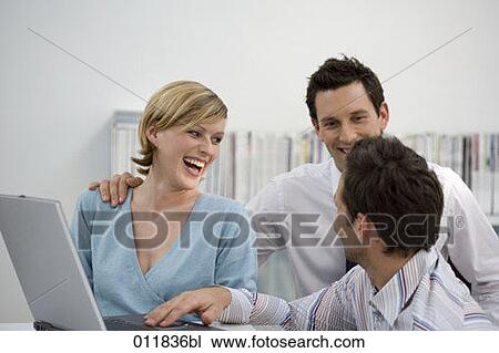 group of office workers sharing a laugh while working with laptop View Large Photo Image Stock Image - group of office workers sharing a laugh while working with laptop. Fotosearch