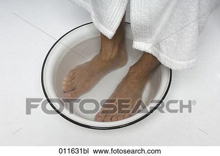 Stock Image - high angle view of feet taking a footbath. Fotosearch