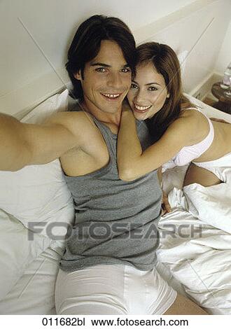 Stock Image - high angle view of young couple taking picture of themselves. Fotosearch
