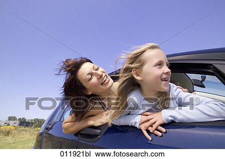 Stock Image - little girl looking curiosly out of car window. Fotosearch