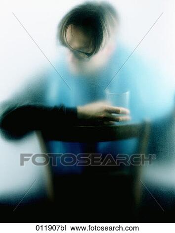 Stock Image - lonely man holding empty glass in his hand. Fotosearch