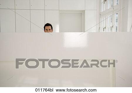 Stock Image - male receptionist hidden behind his desk. Fotosearch
