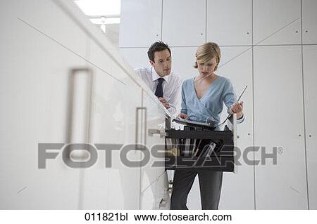 Stock Image - man and woman checking file together. Fotosearch