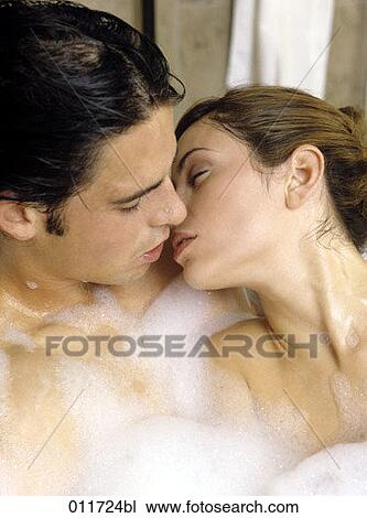Stock Image - man and woman kissing in bubble bath. Fotosearch