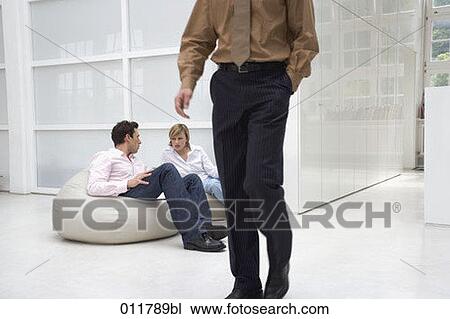man and woman talking in office building while man is passing by in the foreground View Large Photo Image Stock Image - man and woman talking in office building while man is passing by in the foreground. Fotosearch