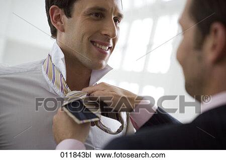 man helping his friend to tie his tie View Large Photo Image Stock Image - man helping his friend to tie his tie. Fotosearch