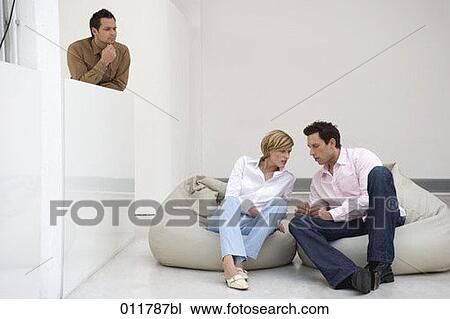 man watching young couple whispering to each other View Large Photo Image Stock Image - man watching young couple whispering to each other. Fotosearch