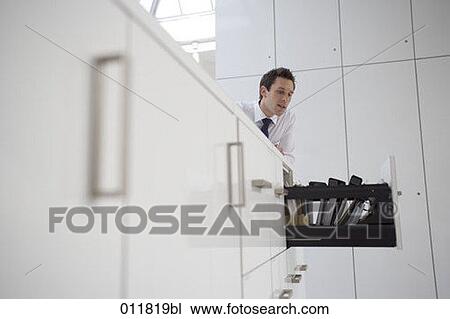 office worker looking at open drawer of filing cabinet View Large Photo Image Stock Image - office worker looking at open drawer of filing cabinet. Fotosearch