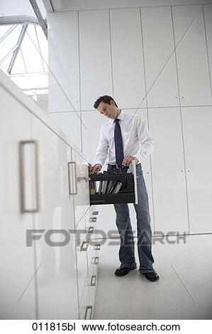 office worker looking through files in drawer View Large Photo Image Stock Image - office worker looking through files in drawer. Fotosearch