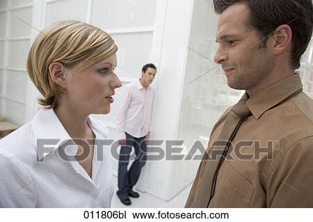 office workers having conversation, man standing in the background View Large Photo Image Stock Image - office workers having conversation, man standing in the background. Fotosearch