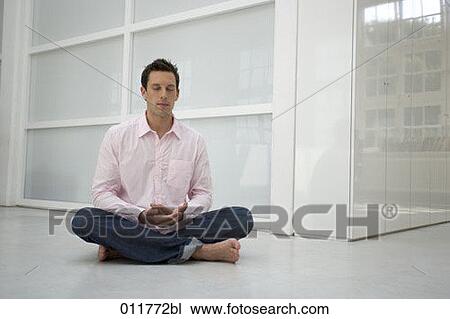 Stock Image - portrait of man meditating in office environment. Fotosearch