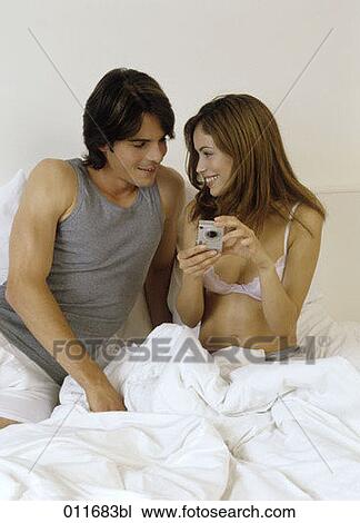 Stock Image - portrait of smiling couple checking digital camera. Fotosearch