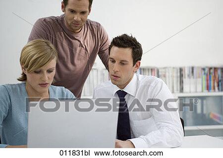 Stock Image - portrait of three people working with laptop computer. Fotosearch
