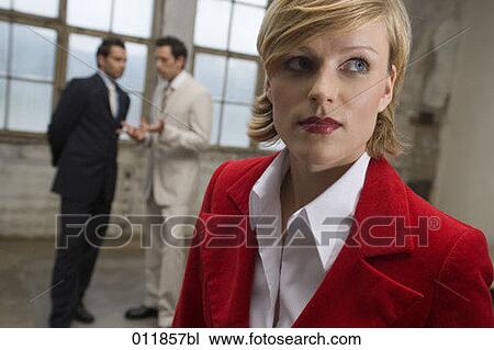 portrait of young businesswoman in empty building with two men in the background having a discussion View Large Photo Image Stock Image - portrait of young businesswoman in empty building with two men in the background having a discussion. Fotosearch