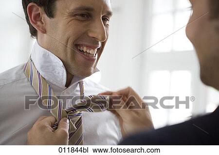 smiling man being helped to tie his tie View Large Photo Image Stock Image - smiling man being helped to tie his tie. Fotosearch