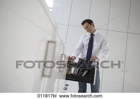smiling office worker thumbing through files in filing cabinet View Large Photo Image Stock Image - smiling office worker thumbing through files in filing cabinet. Fotosearch