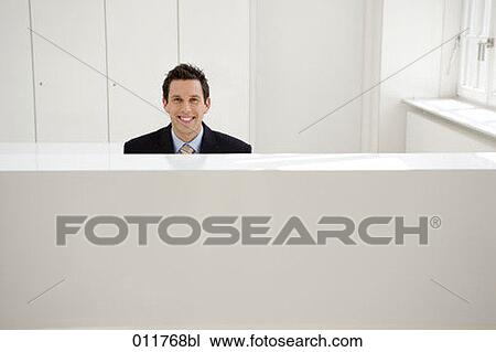 smiling receptionist sitting behind desk View Large Photo Image Stock Image - smiling receptionist sitting behind desk. Fotosearch