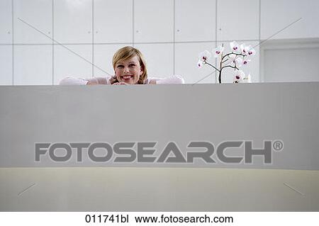 smiling woman leaning on reception desk View Large Photo Image Stock Image - smiling woman leaning on reception desk. Fotosearch