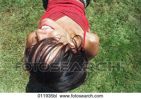 smiling young woman lying in grass View Large Photo Image Stock Image - smiling young woman lying in grass. Fotosearch
