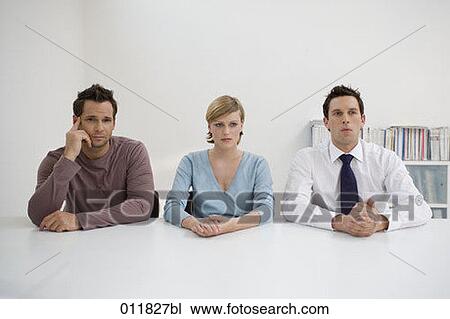 three office workers sitting at a table View Large Photo Image Stock Image - three office workers sitting at a table. Fotosearch