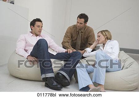 Stock Image - three people sitting on bean bags having a conversation. Fotosearch