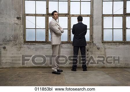 two businessmen standing in front of window View Large Photo Image Stock Image - two businessmen standing in front of window. Fotosearch
