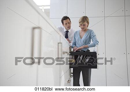 two office workers looking for a file in a filing cabinet View Large Photo Image Stock Image - two office workers looking for a file in a filing cabinet. Fotosearch