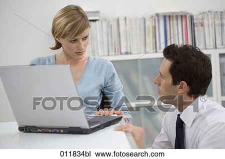 two office workers talking besides laptop computer View Large Photo Image Stock Image - two office workers talking besides laptop computer. Fotosearch
