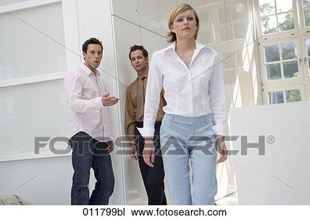 two talking behind the back of passing by woman View Large Photo Image Stock Image - two talking behind the back of passing by woman. Fotosearch