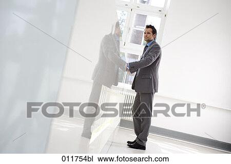 Stock Image - young businessman waiting at reception in office building. Fotosearch