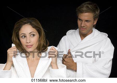 young couple putting on bathrobes View Large Photo Image Stock Image - young couple putting on bathrobes. Fotosearch