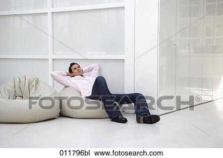 Stock Image - young man day-dreaming on bean bag. Fotosearch