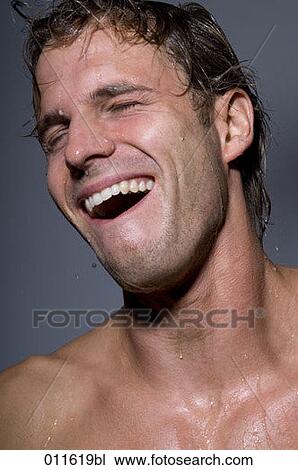 Stock Image - young man laughing while taking a shower. Fotosearch