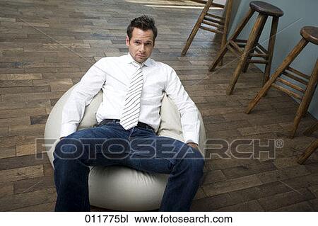 Stock Image - young man sitting on bean bag. Fotosearch