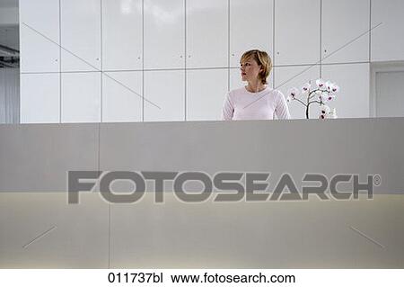 young receptionist standing behind desk View Large Photo Image Stock Image - young receptionist standing behind desk. Fotosearch