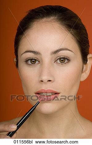 young woman putting on some lip-gloss View Large Photo Image Stock Image - young woman putting on some lip-gloss. Fotosearch