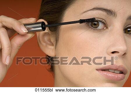 young woman putting on some mascara View Large Photo Image Stock Image - young woman putting on some mascara. Fotosearch