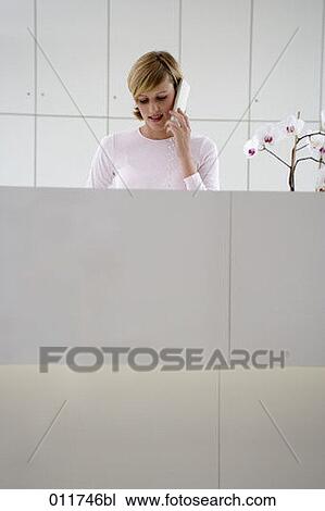 young woman talking on the telephone at office reception View Large Photo Image Stock Image - young woman talking on the telephone at office reception. Fotosearch